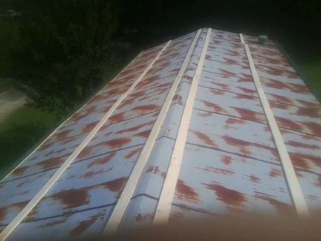 Rusted metal roof panels with new wood purlins before replacement — Storm Damage Roof Repair in Metamora by Roofing Brothers